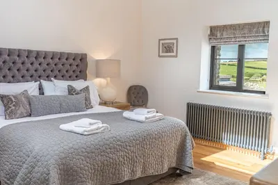 a bedroom with a large bed with towels on it at Old Stable in Ulverston