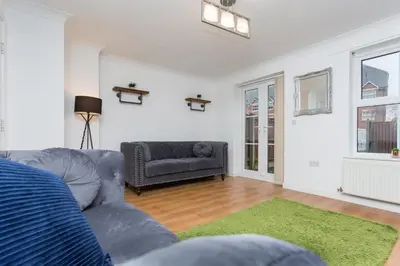 a living room with a couch and a green rug at Great Park Townhouse in Preston