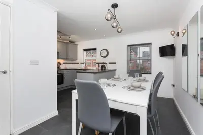 a kitchen and dining room with a white table and chairs at Great Park Townhouse in Preston