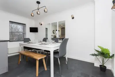 a dining room with a white table and chairs at Great Park Townhouse in Preston