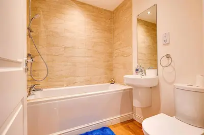 a bathroom with a tub and a toilet and a sink at Cosy 2 Bedroom Home in Wigan in Wigan