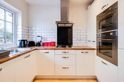 a kitchen with white cabinets and a stove top oven at Cosy 2 Bedroom Home in Wigan in Wigan