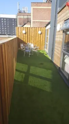a patio with tables and chairs on a balcony at City CTR Penthouse - rooftop bar, sleeps 19 in Liverpool