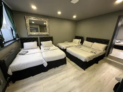 three beds in a room with a mirror at City CTR Penthouse - rooftop bar, sleeps 19 in Liverpool