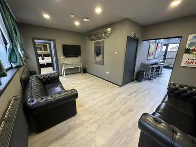a living room with leather furniture and a flat screen tv at City CTR Penthouse - rooftop bar, sleeps 19 in Liverpool