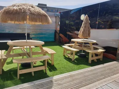 two picnic tables and a table with an umbrella at City CTR Penthouse - rooftop bar, sleeps 19 in Liverpool