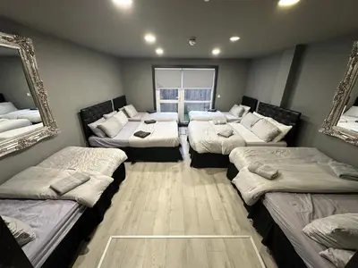 a room with four beds and a mirror at City CTR Penthouse - rooftop bar, sleeps 19 in Liverpool
