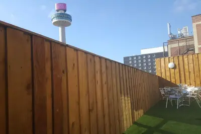 a fence with a table and chairs and a water tower at City CTR Penthouse - rooftop bar, sleeps 19 in Liverpool