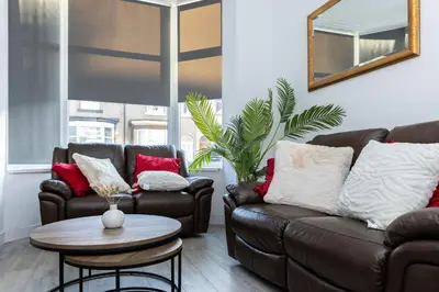a living room with two couches and a table at Warwick West in Barrow in Furness