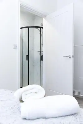 a white bedroom with a bed with two towels at Warwick West in Barrow in Furness