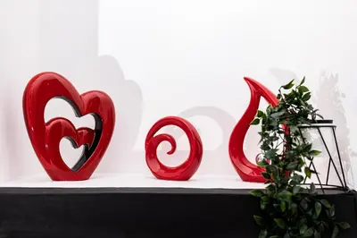 three red heart sculptures sitting on a shelf with a plant at Warwick West in Barrow in Furness