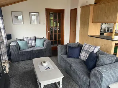 a living room with two couches and a coffee table at Lake View Lodge in Millom