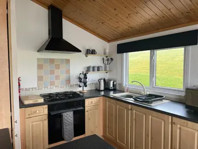 a kitchen with a stove and a sink at Lake View Lodge in Millom