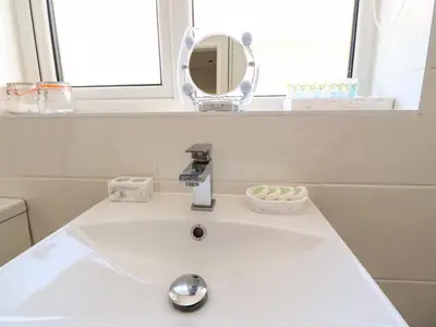 a white sink in a bathroom with a mirror at Bungalow by the Sea in Cleveleys