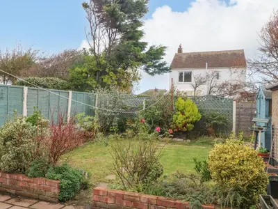 a garden with a fence and a house at Bungalow by the Sea in Cleveleys