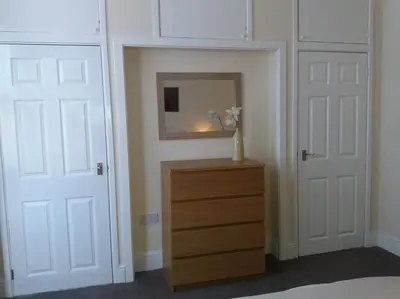 a bedroom with two doors and a dresser with a mirror at Home from Home near LFC & train station in Liverpool