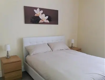 a bedroom with a white bed and two night stands at Home from Home near LFC & train station in Liverpool