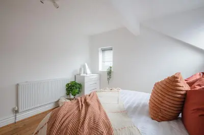 a white bedroom with a bed and a window at Charles Alexander Short Stay - Hove Suite in Lytham St Annes