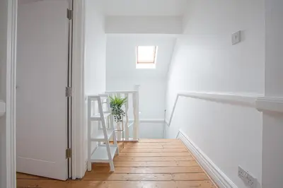a white hallway with a ladder and a stair case at Charles Alexander Short Stay - Hove Suite in Lytham St Annes