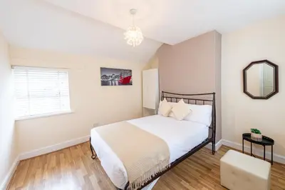 a bedroom with a bed and a mirror and a window at Holly Room in Liverpool