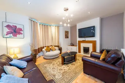 a living room with leather furniture and a tv at Holly Room in Liverpool