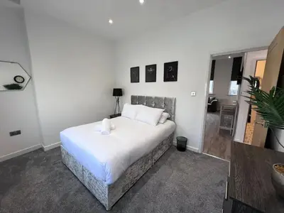 a bedroom with a bed with white sheets and pillows at Monthly Stays Liverpool in Liverpool