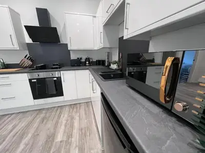 a kitchen with white cabinets and black appliances at Monthly Stays Liverpool in Liverpool