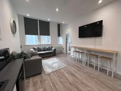 a living room with a couch and a television on a wall at Monthly Stays Liverpool in Liverpool
