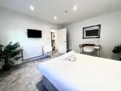 a bedroom with a bed and a flat screen tv at Monthly Stays Liverpool in Liverpool