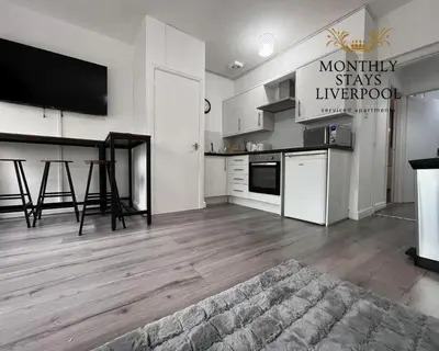 a kitchen with white cabinets and a counter top at Monthly Stays Liverpool in Liverpool