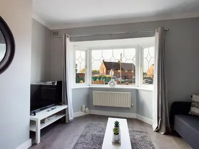 a living room with a couch and a window at Stunning Family Home with Comfortable Surroundings by Our Home Short Stays ideally situated within Greater Manchester in Hindley