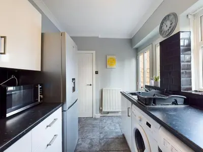 a kitchen with a sink and a microwave at Stunning Family Home with Comfortable Surroundings by Our Home Short Stays ideally situated within Greater Manchester in Hindley
