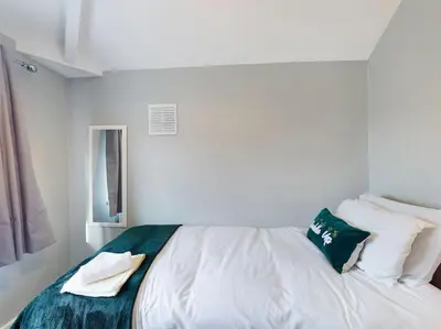 a white bed in a white room with pillows at Stunning Family Home with Comfortable Surroundings by Our Home Short Stays ideally situated within Greater Manchester in Hindley