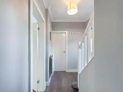 a hallway with white walls and a white door at Stunning Family Home with Comfortable Surroundings by Our Home Short Stays ideally situated within Greater Manchester in Hindley