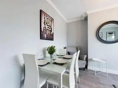 a white dining room with a white table and chairs at Stunning Family Home with Comfortable Surroundings by Our Home Short Stays ideally situated within Greater Manchester in Hindley