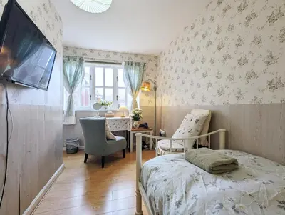 a bedroom with a bed and a chair and a table at City Centre Vintage Theme Guest Rooms in Liverpool