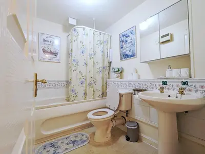 a bathroom with a toilet and a sink and a tub at City Centre Vintage Theme Guest Rooms in Liverpool