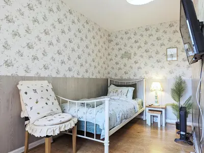 a bedroom with a bed and a chair in it at City Centre Vintage Theme Guest Rooms in Liverpool