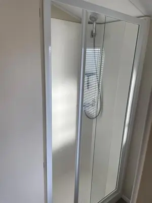 a shower with a glass door in a bathroom at Ocean Edge Morecambe Sea view in Heysham