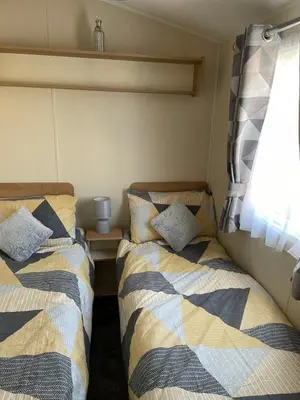 two beds in a small room with a window at Ocean Edge Morecambe Sea view in Heysham