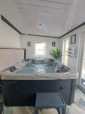 a large bath tub in a bathroom with a table at Family Holiday with Hot tub , Family groups only in Blackpool