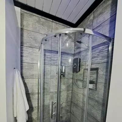 a shower with a glass door in a bathroom at Family Holiday with Hot tub , Family groups only in Blackpool