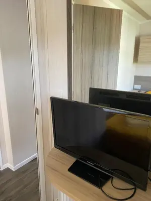 a flat screen tv sitting on top of a wooden stand at Swift Retreat Caravan - Morecambe in Morecambe