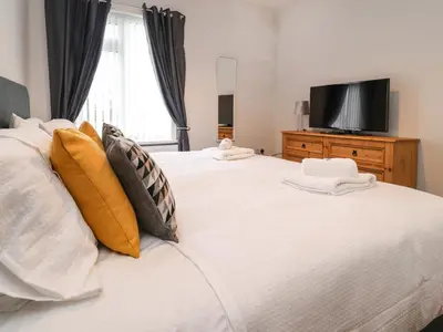 a bedroom with two beds with a television on a dresser at 37 Nutter Road in Cleveleys