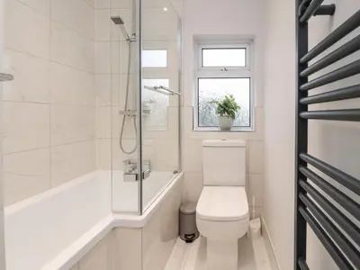 a bathroom with a toilet and a tub and a window at 37 Nutter Road in Cleveleys