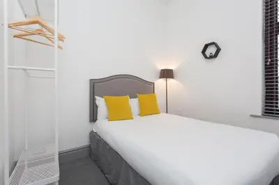 a bedroom with a large bed with yellow pillows at The Station House in Preston