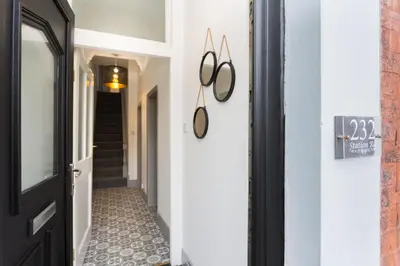 a hallway with a black door and a tile floor at The Station House in Preston