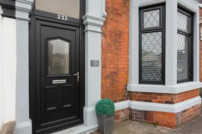 a black door on a brick building with a potted plant at The Station House in Preston
