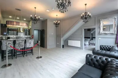 a living room with a couch and a table and a kitchen at Manhattan Suite - sleeps 24! Heart of Liverpool in Liverpool