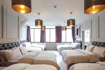 a room with a bunch of white couches and windows at Manhattan Suite - sleeps 24! Heart of Liverpool in Liverpool